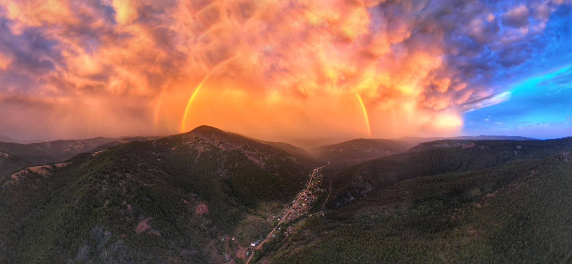 Neihart from the air at sunset, with a rainbow over the mountain
