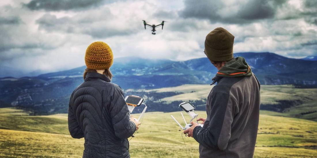 Two people flying a drone over the Little Belts