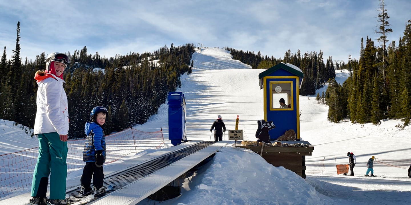 Skiers at the bottom of a groomed run at Showdown